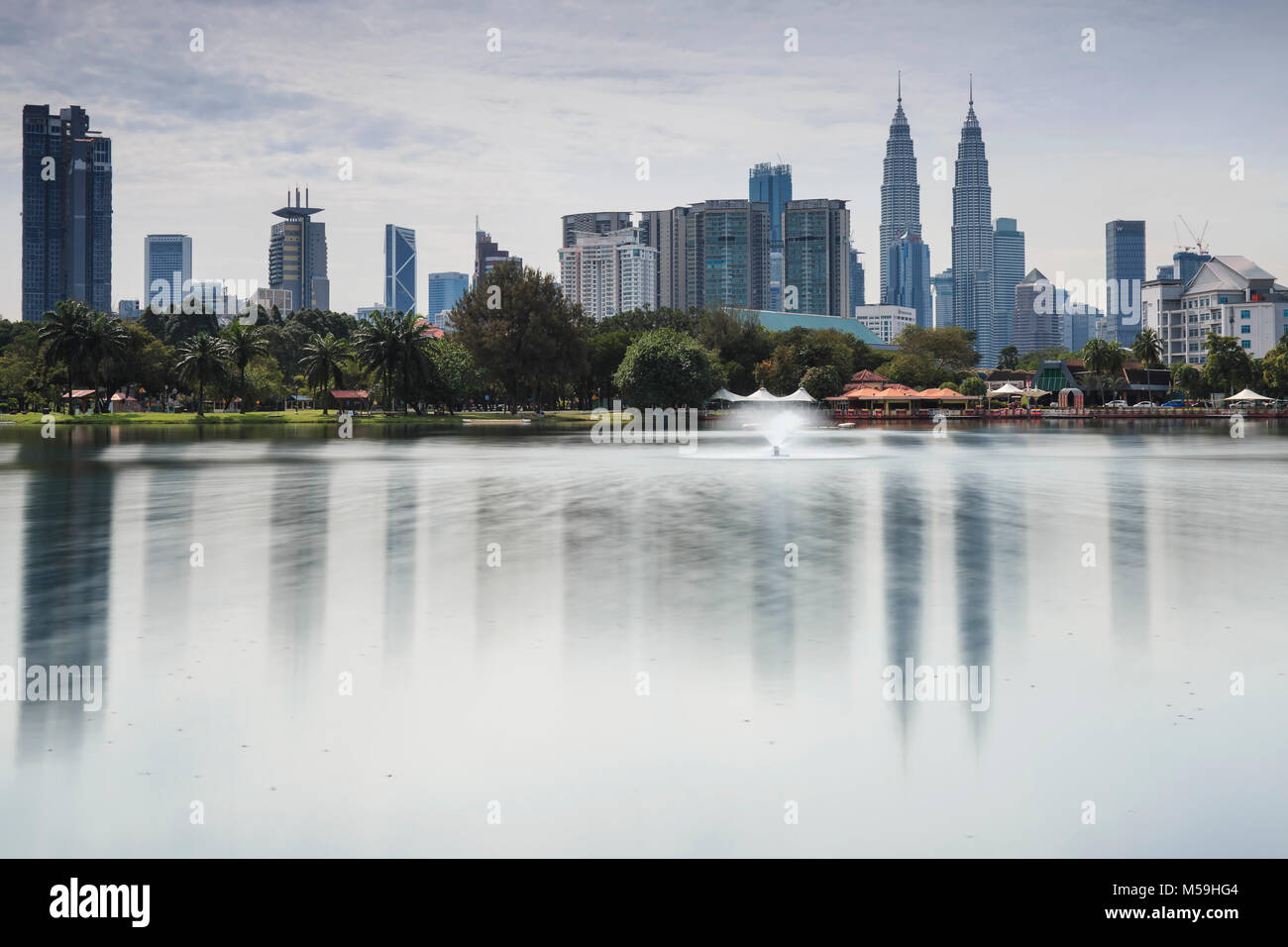 La ville de Kuala Lumpur à midi avec Petronas Towers reflétée sur le lac Titiwangsa Banque D'Images