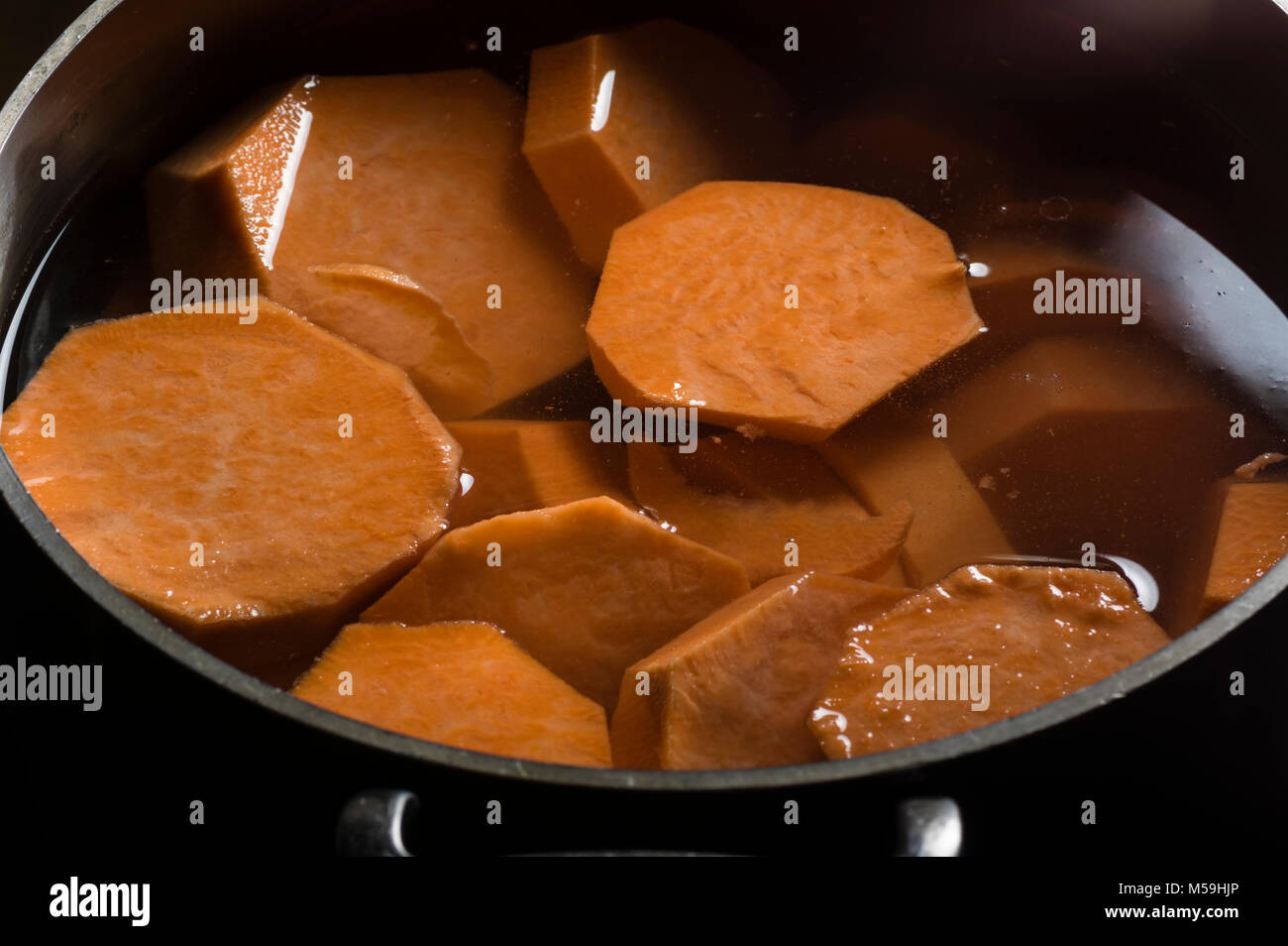 Morceaux d'igname ou de patates douces dans une marmite bouillante Banque D'Images