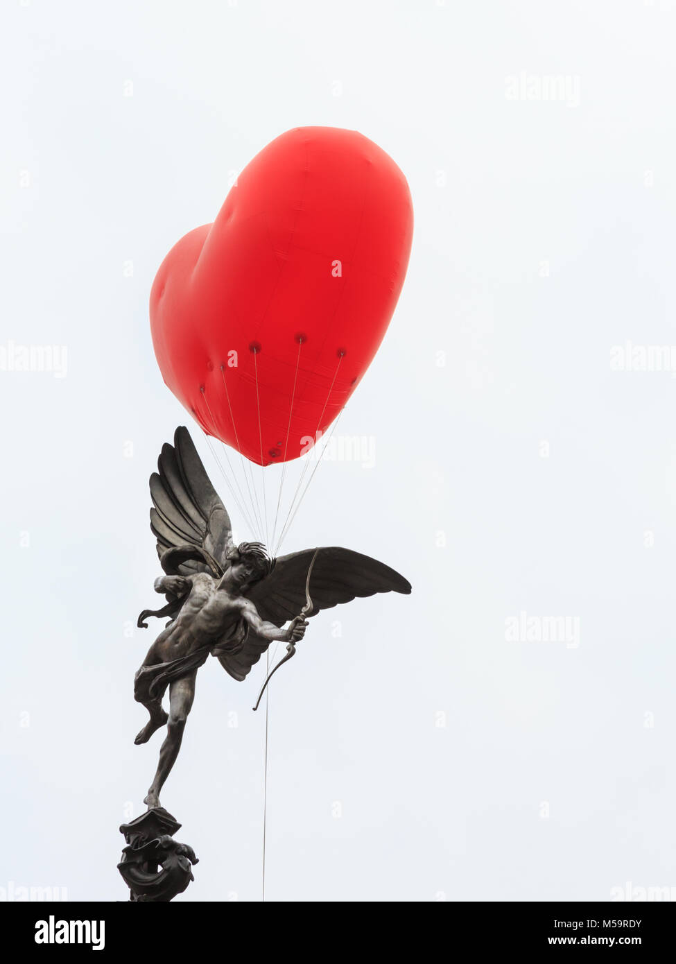 Piccadilly Circus, Londres, 21 février 2018. Un coeur chubby apparaît sur Piccadilly Circus et la statue d'Eros, un symbole de l'amour, dans le centre de Londres. Commençant le jour de la Saint-Valentin et tout au long de la Semaine de la mode de Londres, giant chubby ballons coeur par Anya Hindmarch sont suspendus au-dessus de Londres comme une déclaration d'amour à la ville. Les ballons disparaissent chaque soir et apparaissent à nouveau dans un autre endroit le jour suivant. Credit : Imageplotter News et Sports/Alamy Live News Banque D'Images