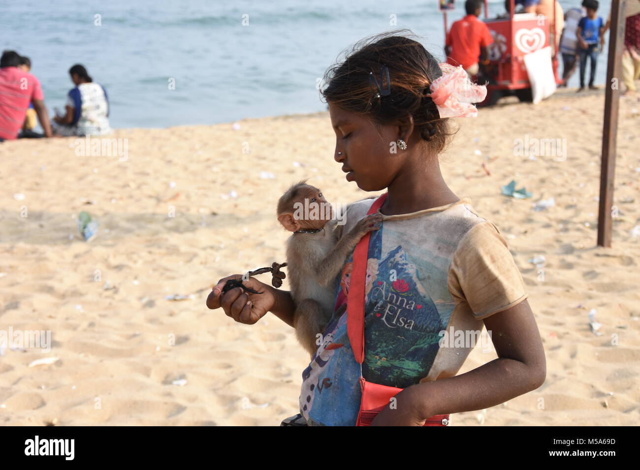 Petit mendiant fille avec son petit singe ami sur marina beach, Chennai, Inde Banque D'Images