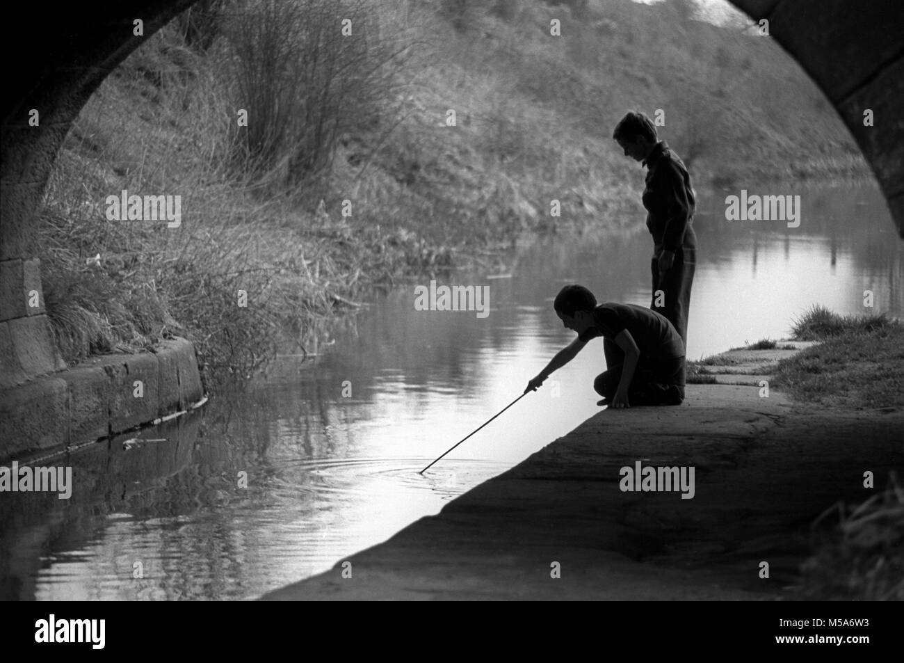 Royaume-uni, Angleterre, Cheshire, Congleton, Buglawton, enfants jouant avec stick à Macclesfield Canal Banque D'Images