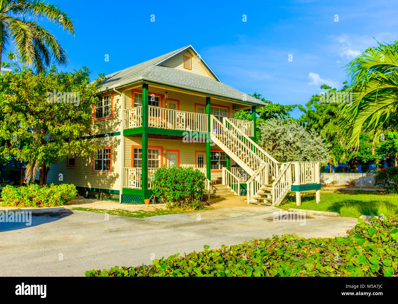 Grand Cayman, Cayman Islands, deux étages de style Caraïbes colorés maison avec un jardin à l'avant dans le quartier de West Bay Banque D'Images