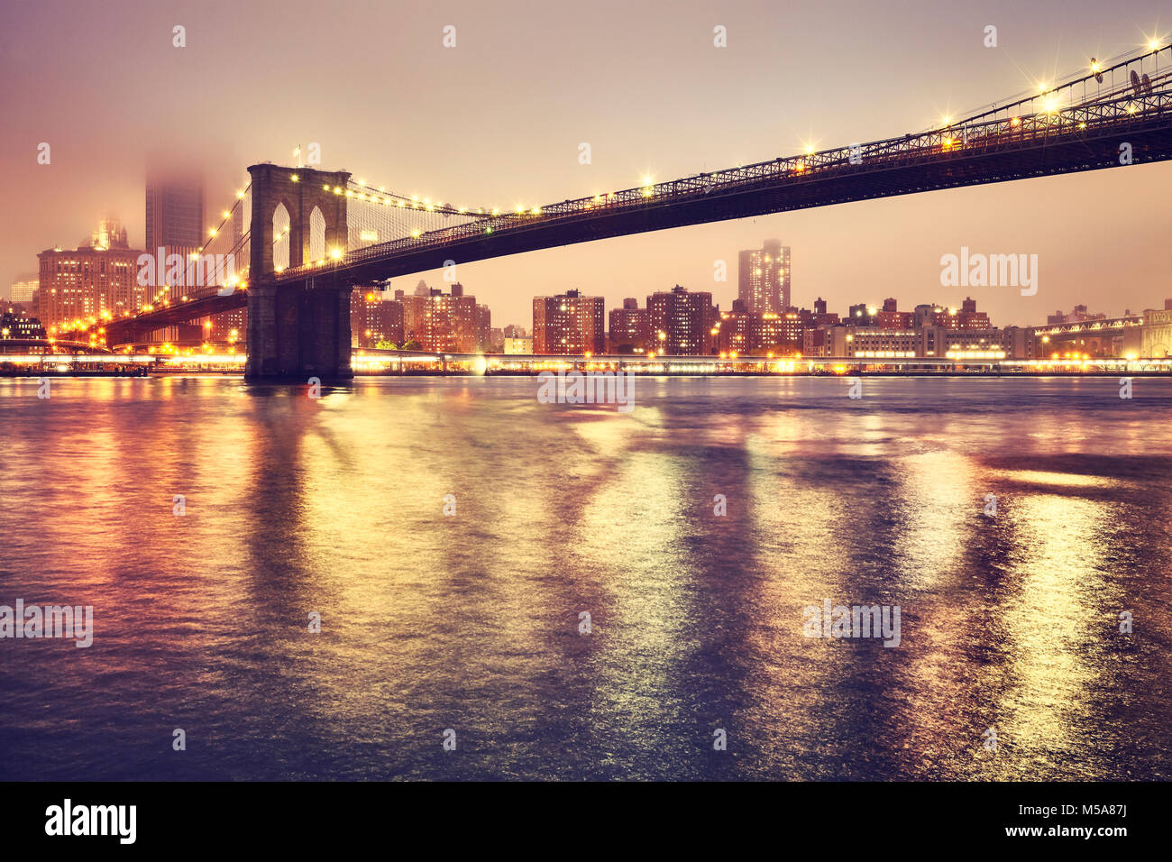 Brooklyn Bridge et le Manhattan sur une nuit brumeuse, tons de couleur photo, New York City, USA. Banque D'Images