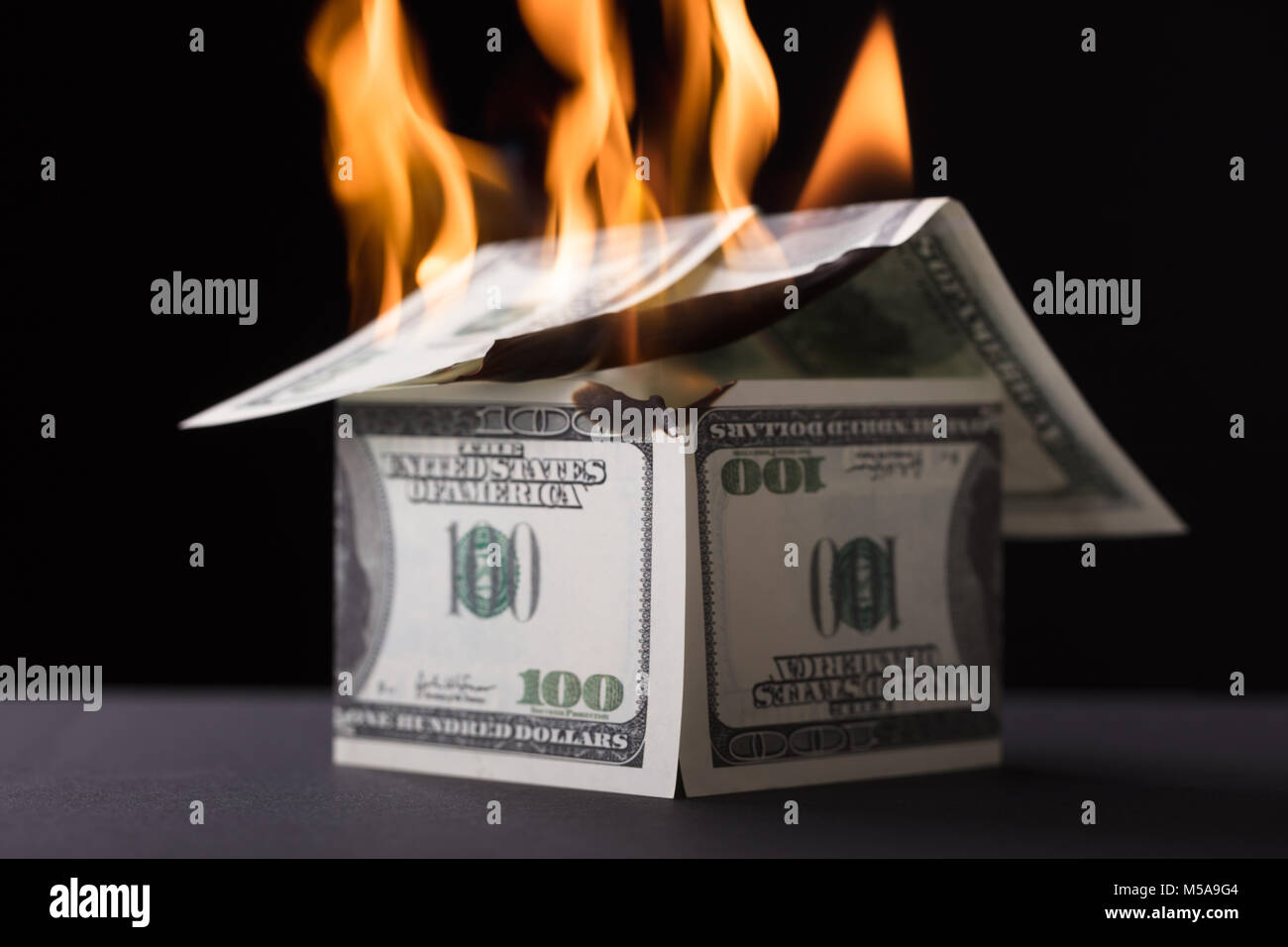 Chambre composé de brûler des billets dans le feu sur fond noir Banque D'Images