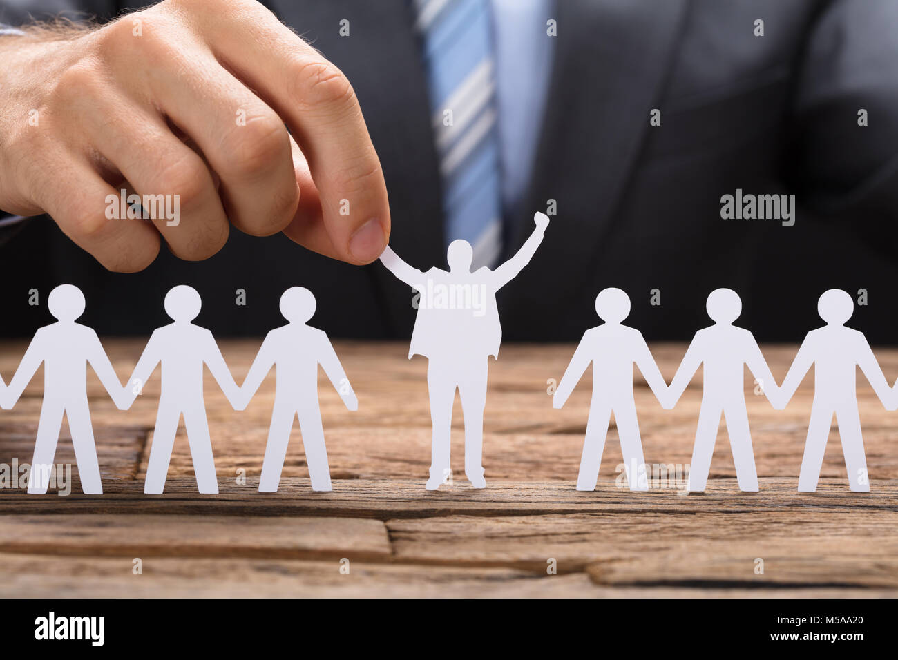 Portrait of businessman holding papier réussie au milieu de table sur l'équipe de direction Banque D'Images