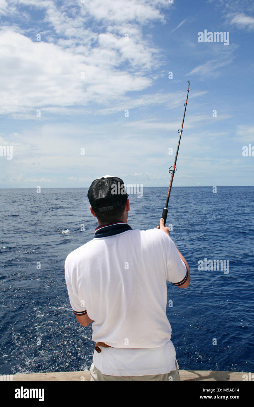 Un pêcheur dans un bateau lutte contre un poisson. La pêche en haute mer Banque D'Images