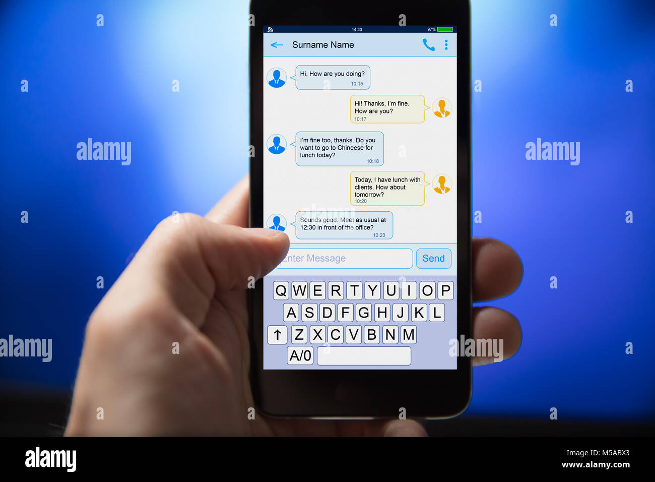 Close-up of a l'envoi de message texte à partir de téléphone mobile sur fond bleu Banque D'Images