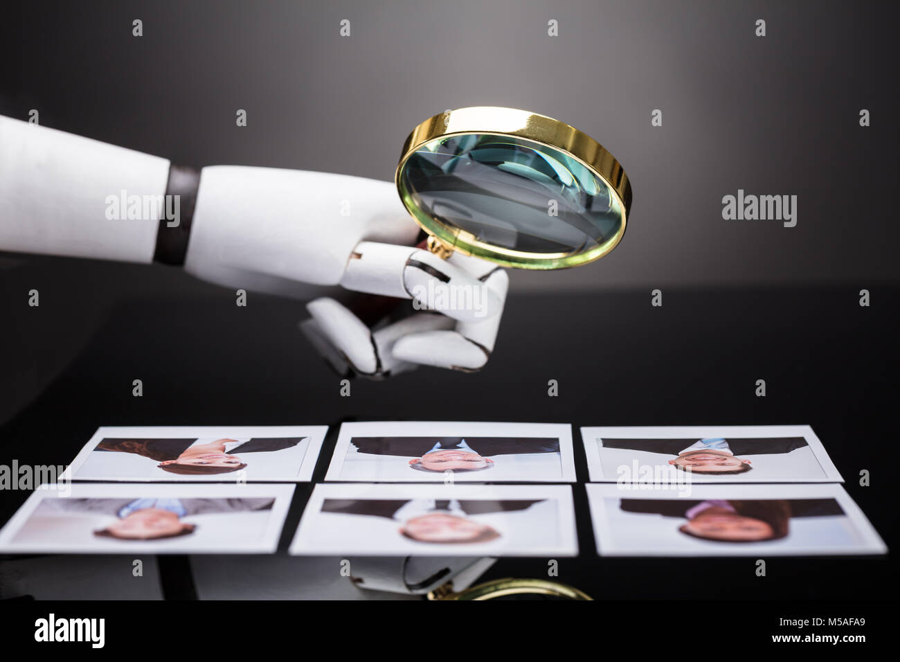 Close-up de la main d'un robot à la photographie avec les candidats à la loupe Banque D'Images