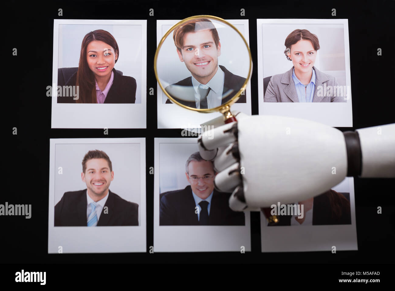 Close-up de la main d'un robot à la photographie avec les candidats à la loupe Banque D'Images