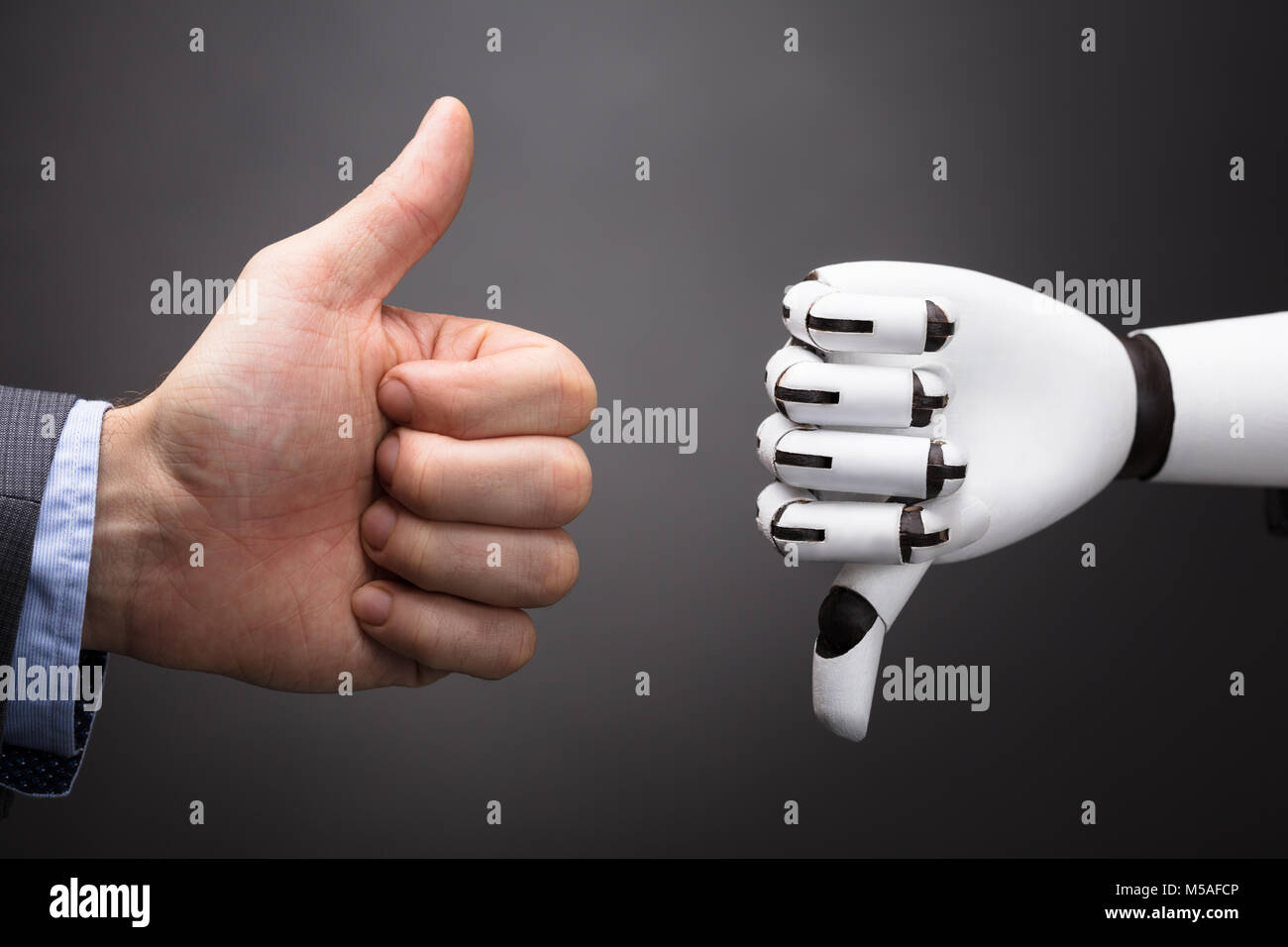 D'affaires et du Robot Showing Thumb Up et le pouce vers le bas signe sur fond gris Banque D'Images