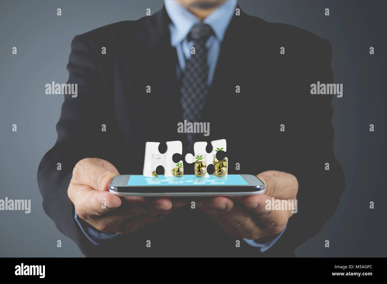 Part of businessman holding smart phone tactile bleu. Avec la main de pièce de puzzle. Les mains à l'homme d'écrans virtuels technologie concept. Banque D'Images