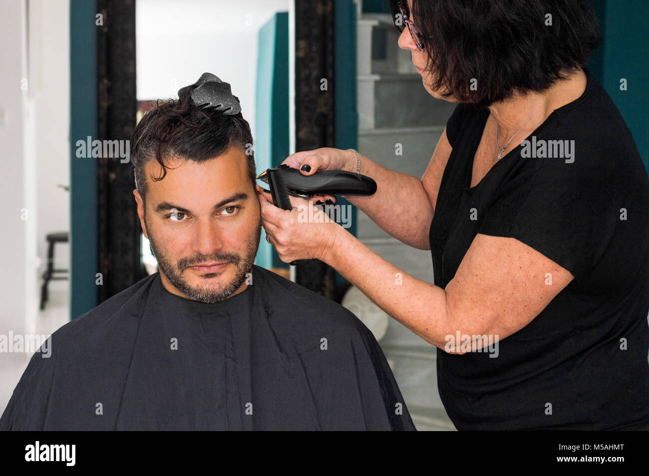 Coiffure femme travaillant avec les jeunes de Rasoir Tondeuse à cheveux, tête de l'homme Banque D'Images