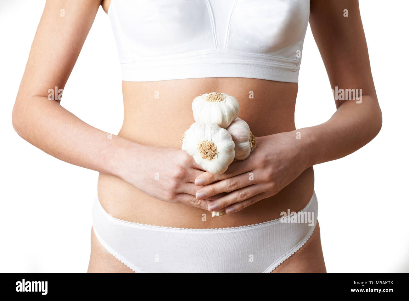 Close Up of Woman in Underwear Holding Bunch d'Ail Banque D'Images