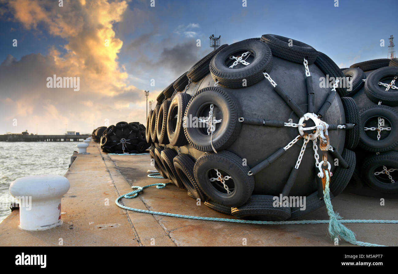 Le grand navire flottant en caoutchouc de protection sur le port du fret bouée photo dans l'heure du coucher du soleil en plein air et un éclairage chaleureux. Banque D'Images