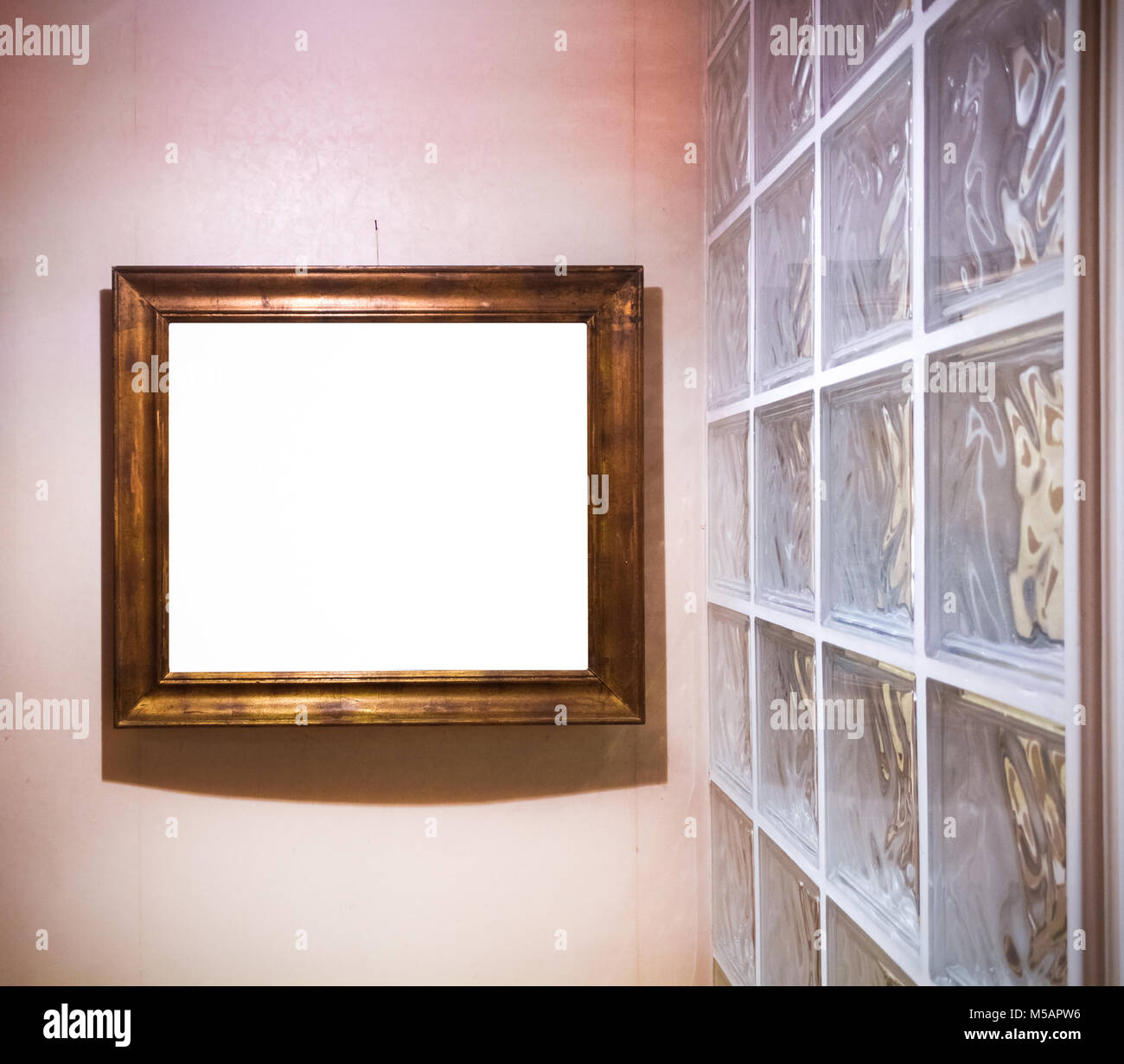 Un cadre doré antique vide par un mur de verre. L'éclairage rouge intéressant Banque D'Images