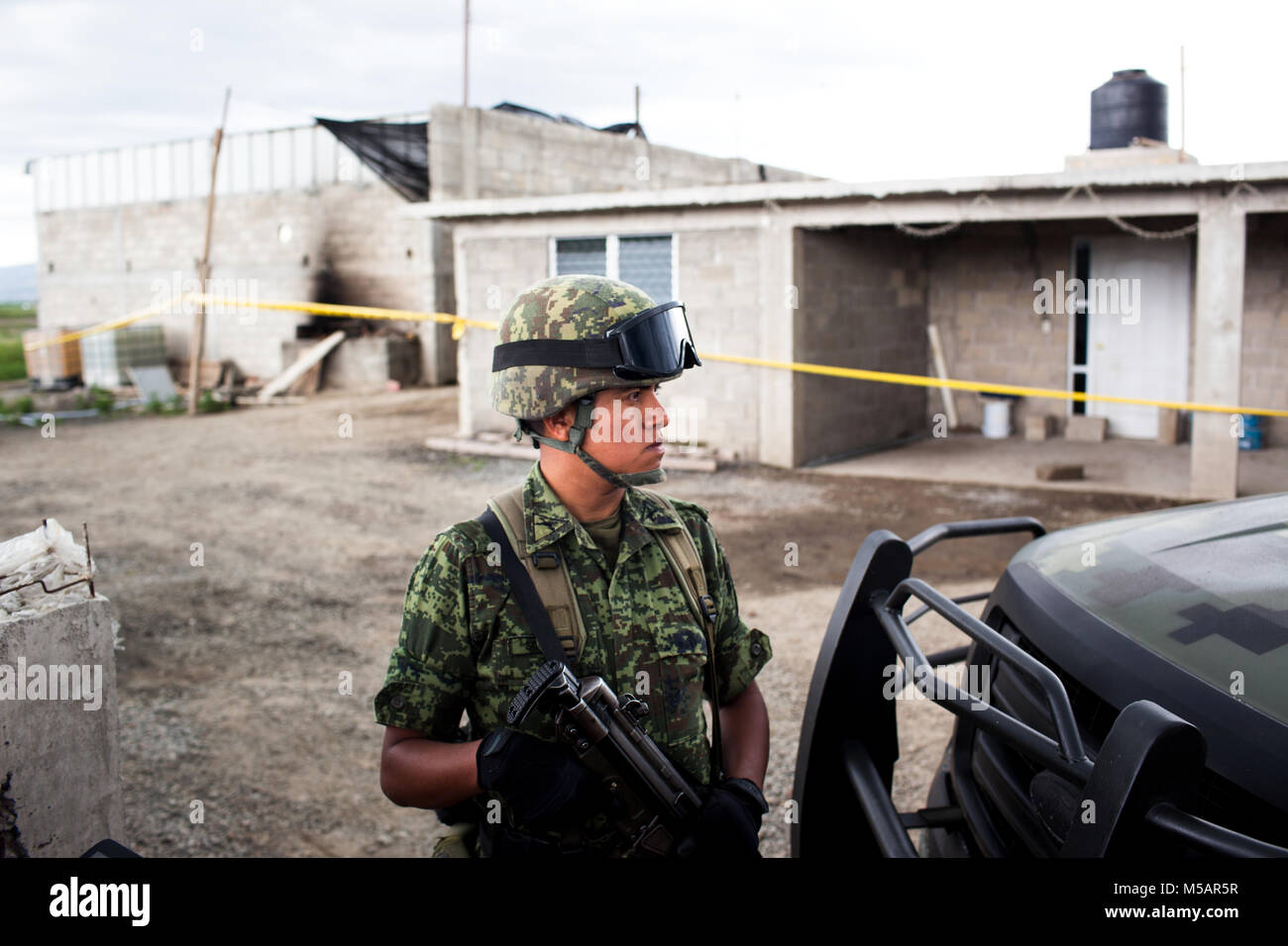 Un soldat de l'armée mexicaine garde une petite ferme maison qui a été utilisé par Joaquin "El Chapo" Guzman pour échapper à la prison de l'Altiplano près de Toluca, Mexique le dimanche 12 juillet 2015. Le célèbre chef du cartel Joaquin "El Chapo" Guzman s'est échappé de cette prison de haute sécurité la nuit d'avant à travers un tunnel. C'est la deuxième fois qu'il a échappé à une prison mexicaine. Banque D'Images