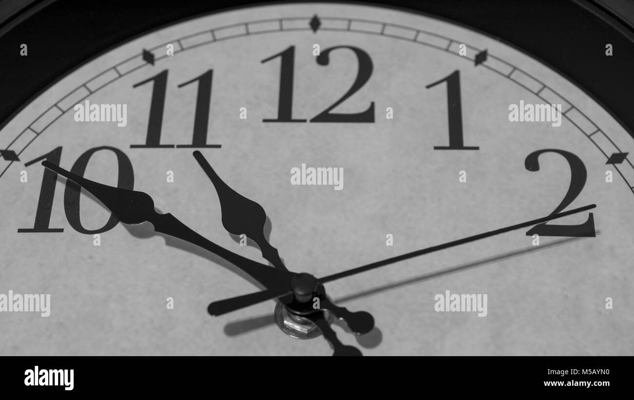 Gros plan sur les pointeurs d'une horloge marquant dix minutes avant 11 heures - le rendu noir et blanc Banque D'Images