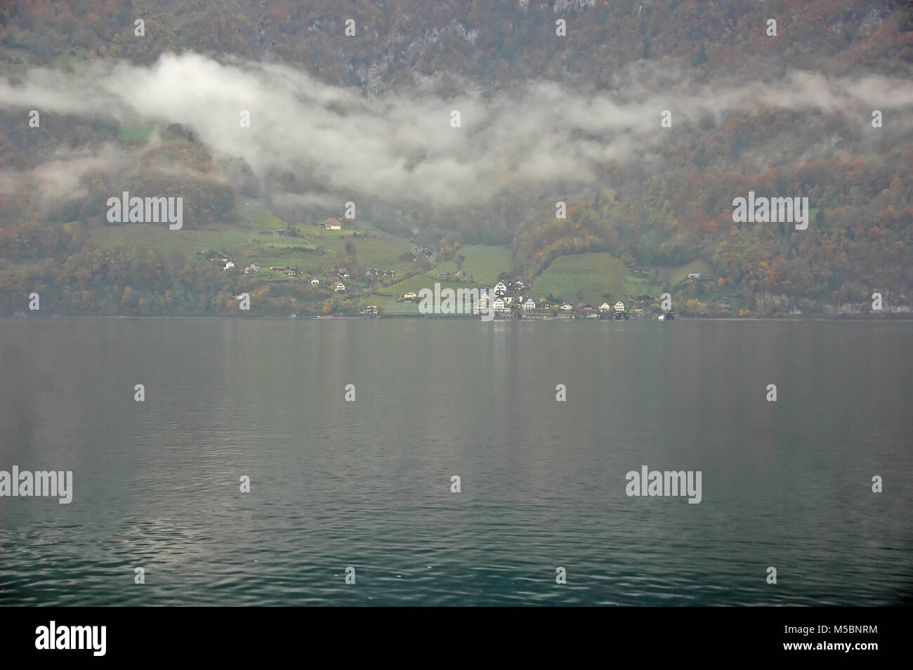 Le village isolé de Quentin sur le lac de Walenstadt en Suisse. Le seul accès se fait par bateau. Un jour nuageux à l'automne Banque D'Images