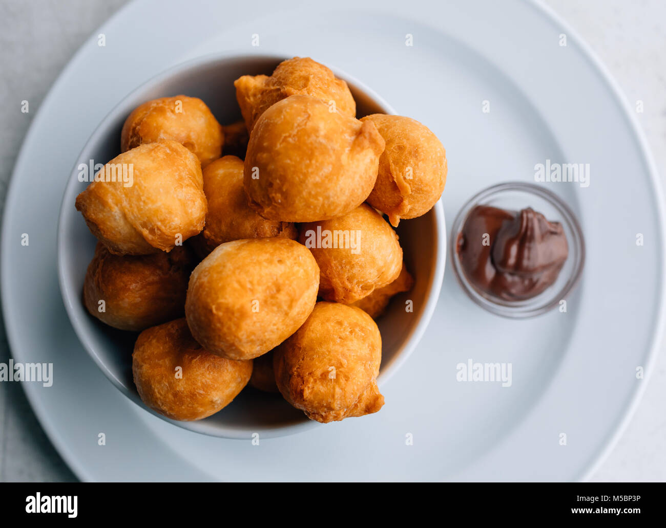 Beignets de carnaval ou des beignes ou bunuelos servi avec de la crème pour le petit-déjeuner. La cuisine traditionnelle serbe - pringice. Banque D'Images