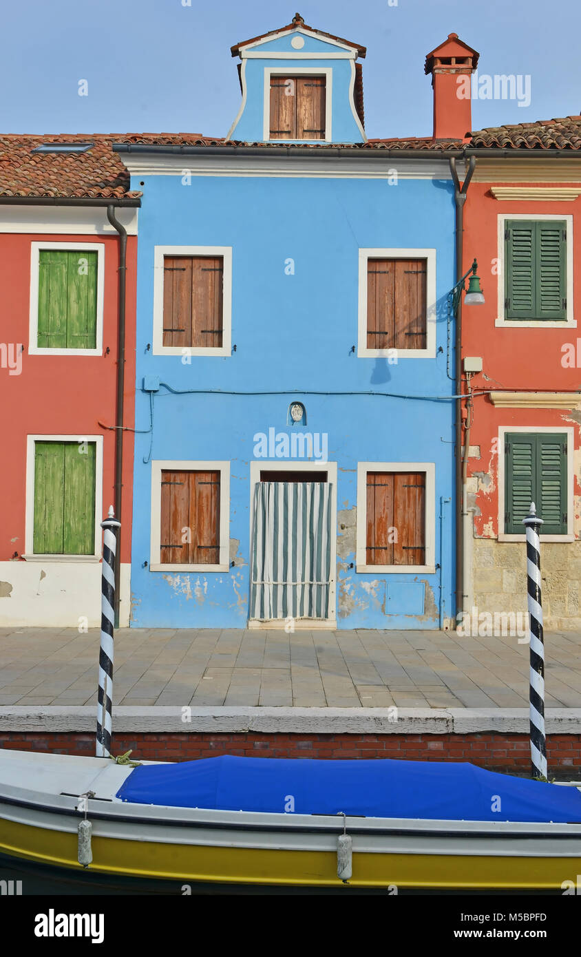 Chambre bleue avec voisins rouge sur l'île de Burano, dans la lagune de Venise, où il n'y a pas deux maisons adjacentes sont de la même couleur. Voile à l'avant Banque D'Images