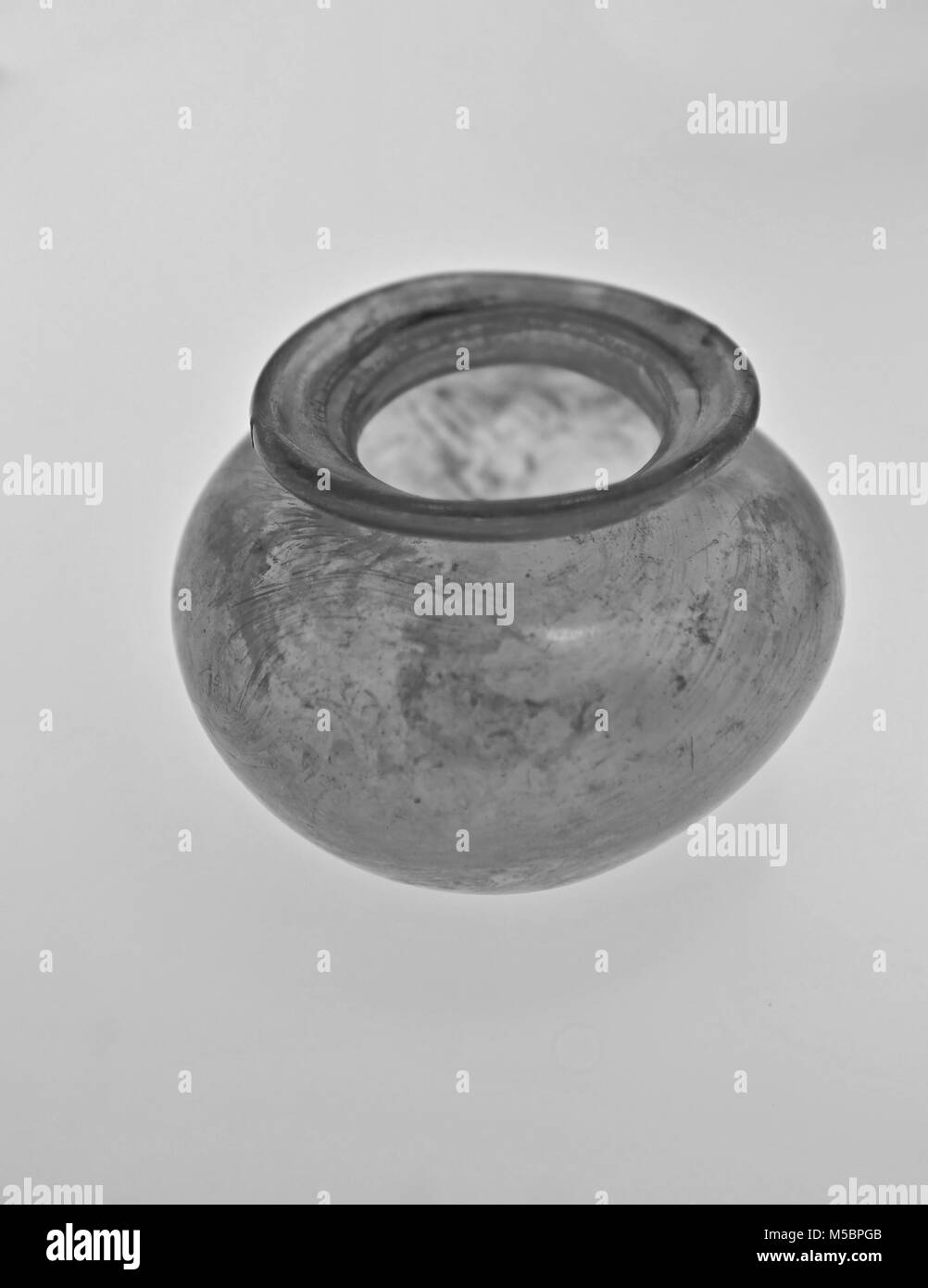 Ancienne cité romaine bol en verre clair avec la lèvre contre un fond orange pâle Banque D'Images