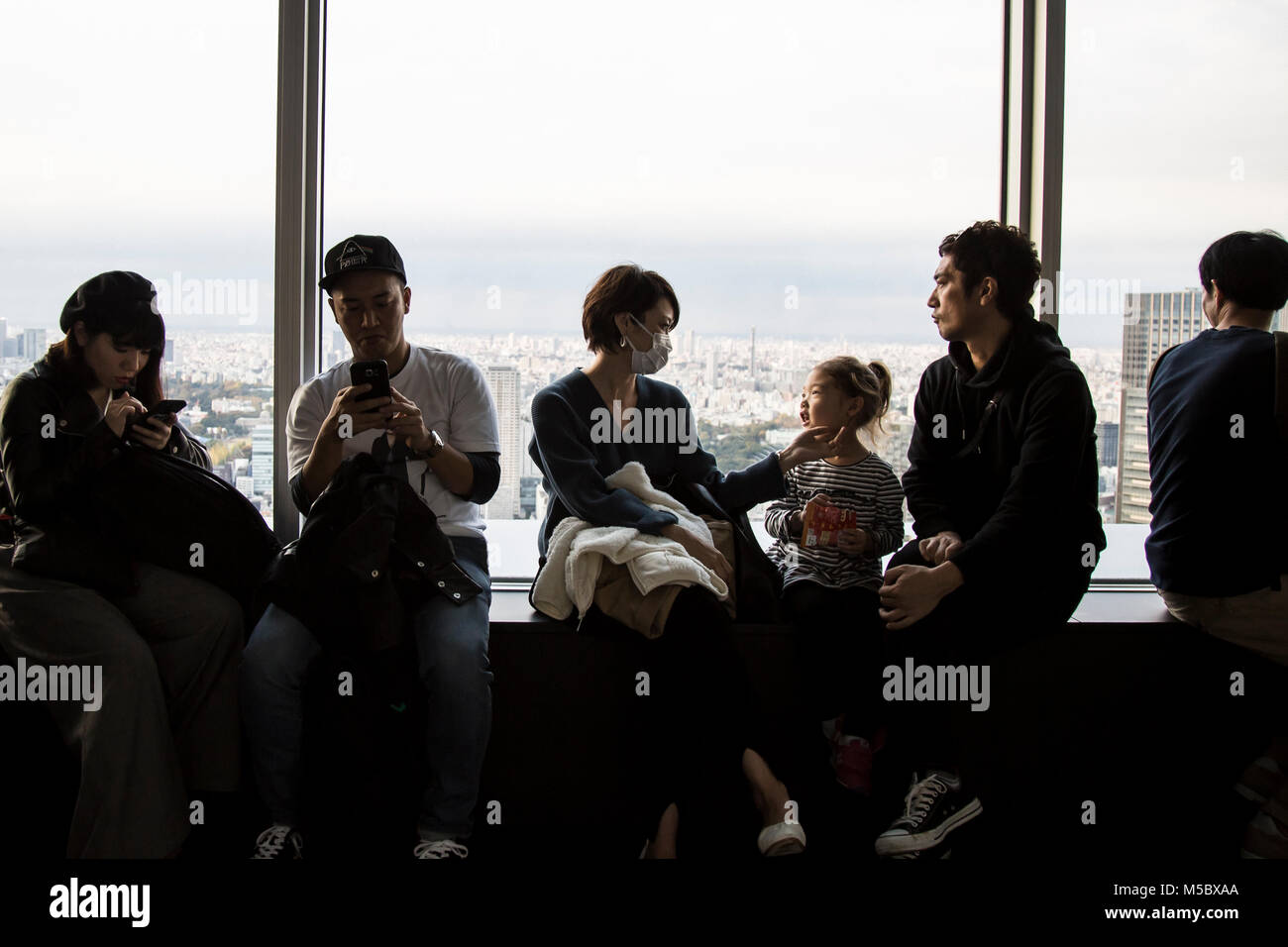 Les touristes s'asseoir à la vue des fenêtres de la terrasse d'observation du Musée d'art Mori Banque D'Images