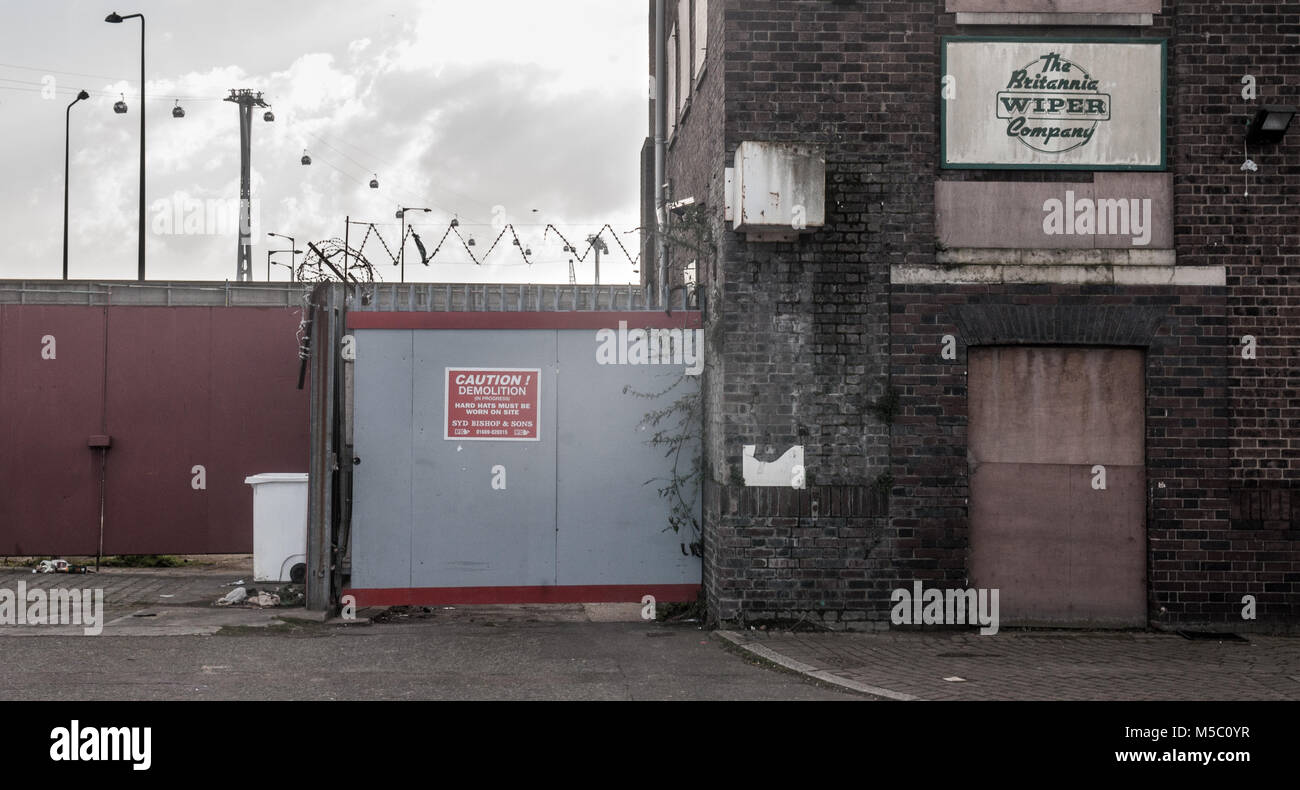 Londres, Angleterre, Royaume-Uni - 17 Février 2013 : Le téléphérique de Thames moderne s'élève derrière barricadèrent entrepôts industriels à Londres est partiellement régénéré R Banque D'Images