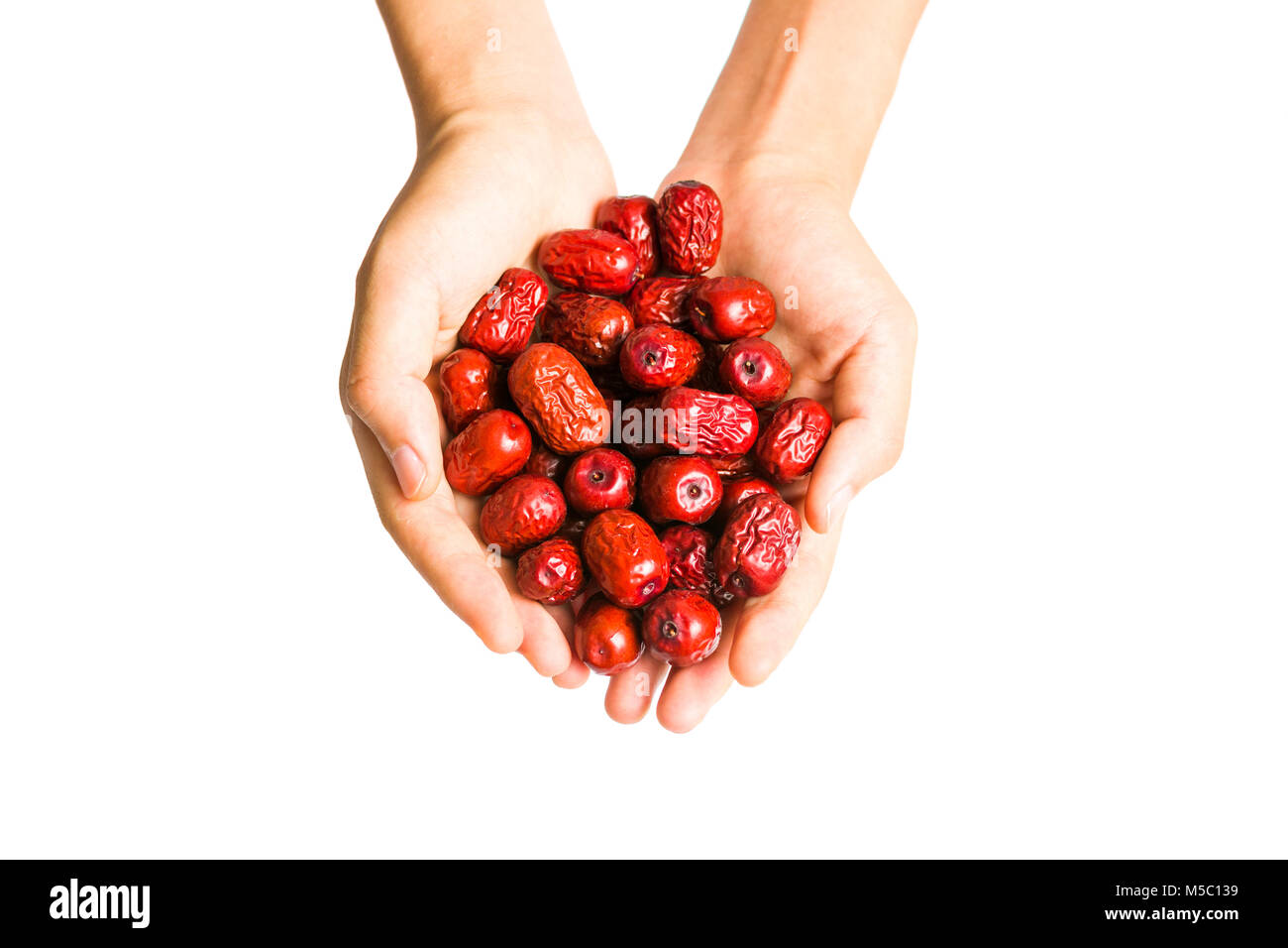 Hand holding red chinois isolés dates séchées Banque D'Images