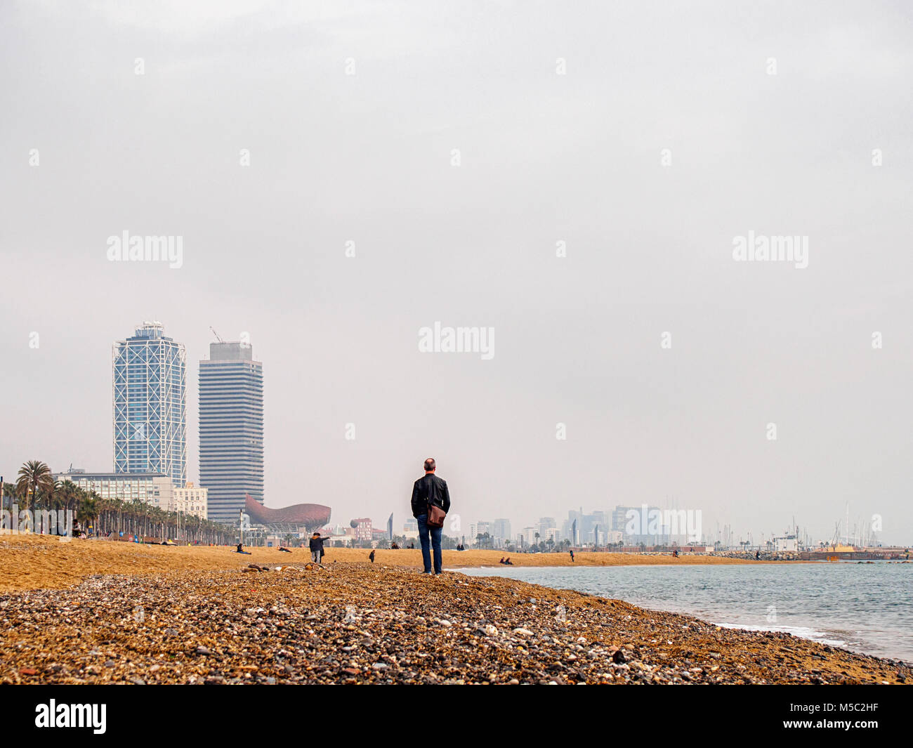 Homme d'âge moyen debout sur la plage de Barcelone Sant Miguel Banque D'Images