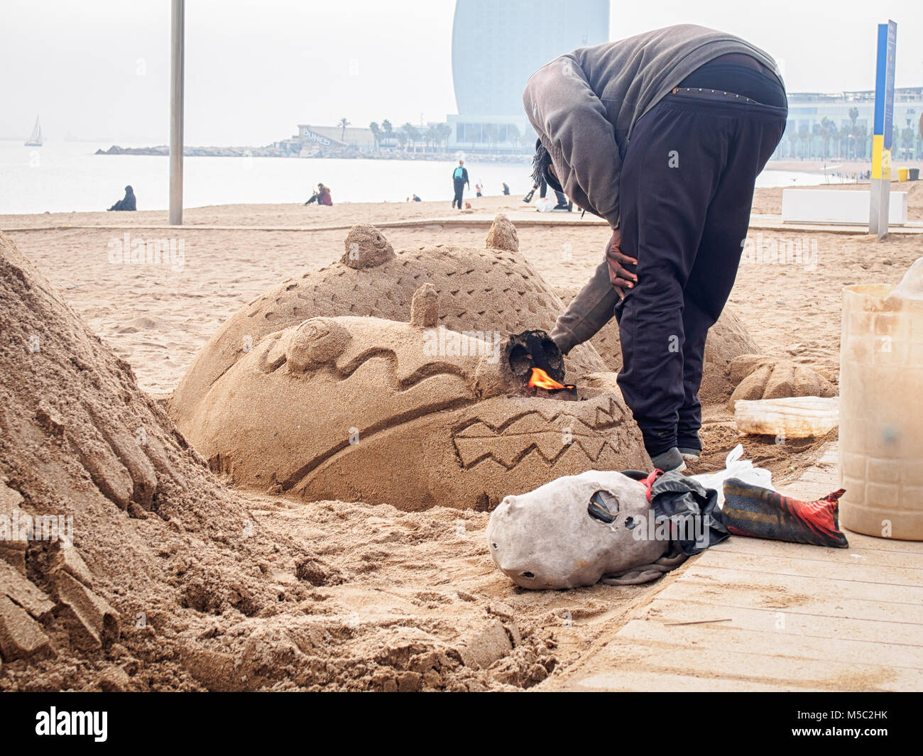 L'homme est de faire une sculpture de sable dragon sur la plage de Barcelone Sant Miguel Banque D'Images