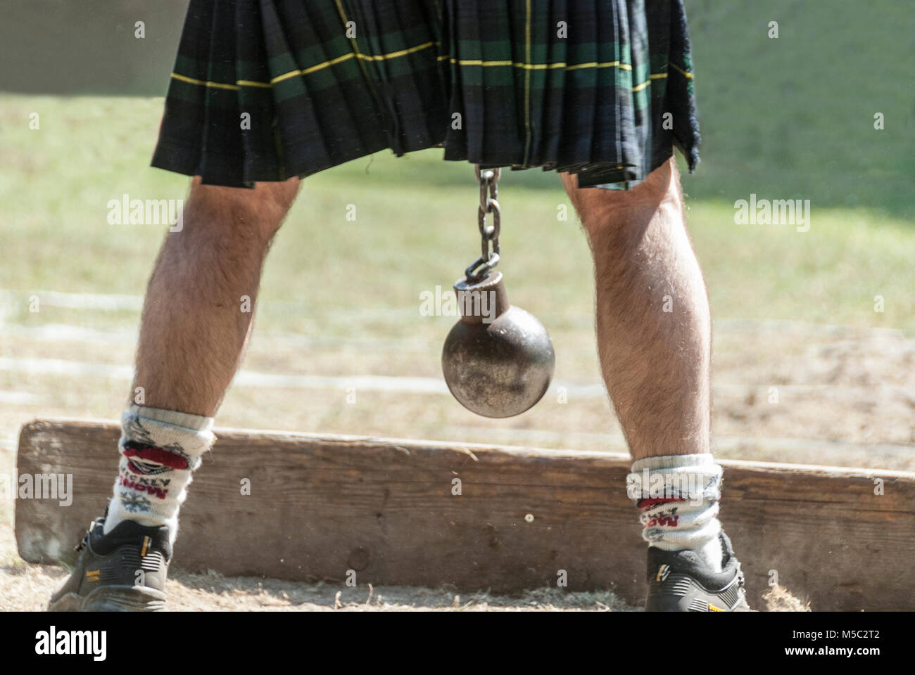 Personne écossais avec kilt et bille de métal entre ses jambes Banque D'Images
