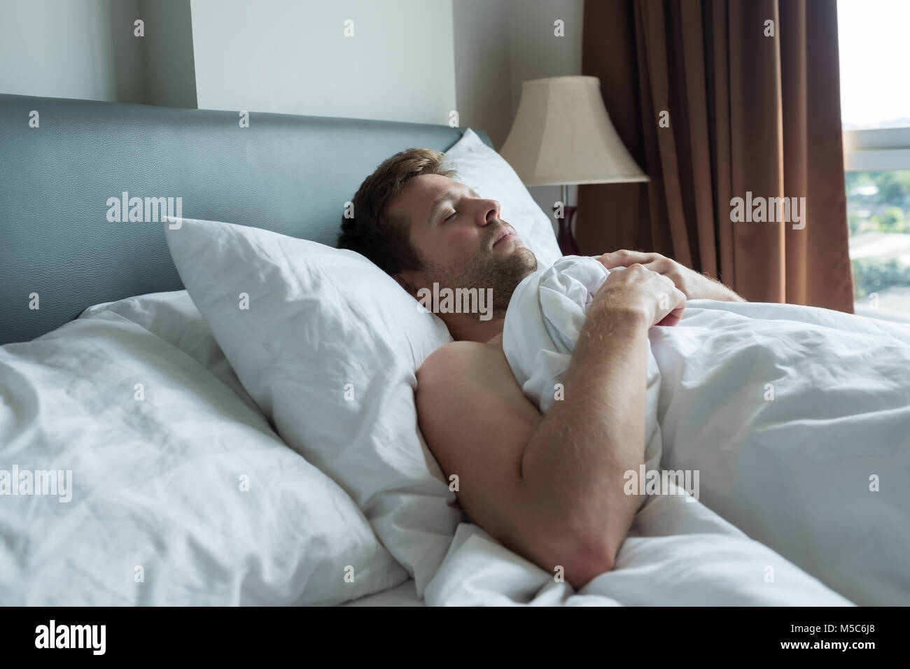 Caucasian man napping avec expression du visage heureux. Banque D'Images