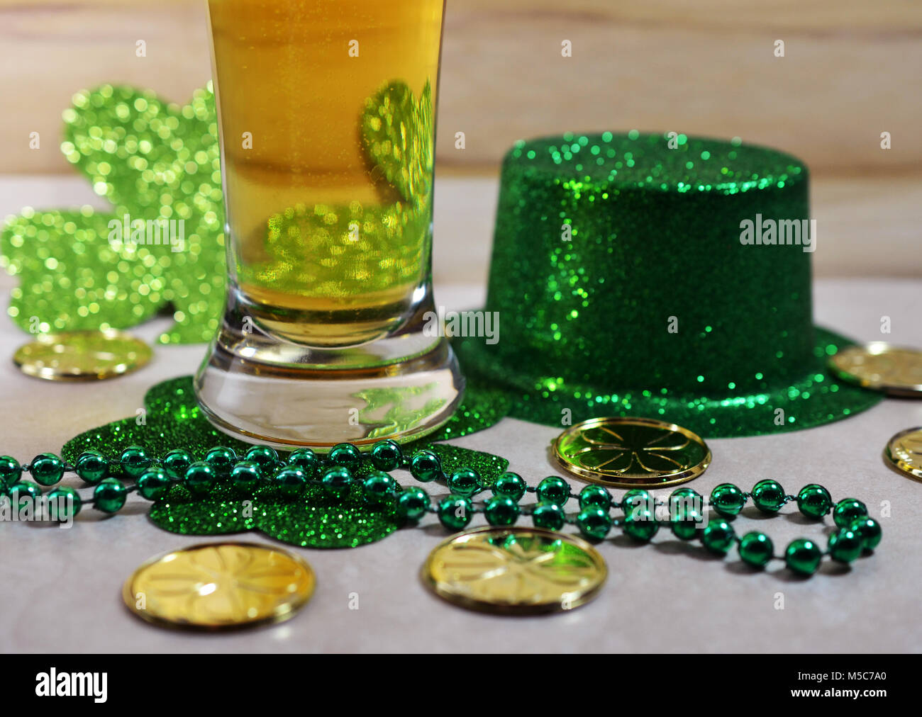 St Patrick's Day Beer verre rempli de bière, perles vert, les pièces d'or et vert top hat. Banque D'Images