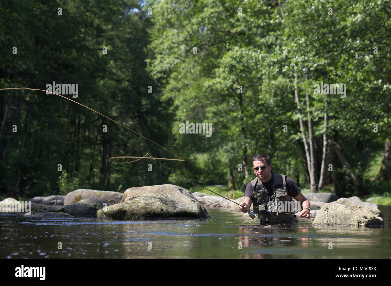 Les pêcheurs à la mouche dans une rivière à truites. Scène de pêche à la mouche Banque D'Images Les pêcheurs à la mouche dans une rivière à truites. Scène de pêche à la mouche Banque D'Images