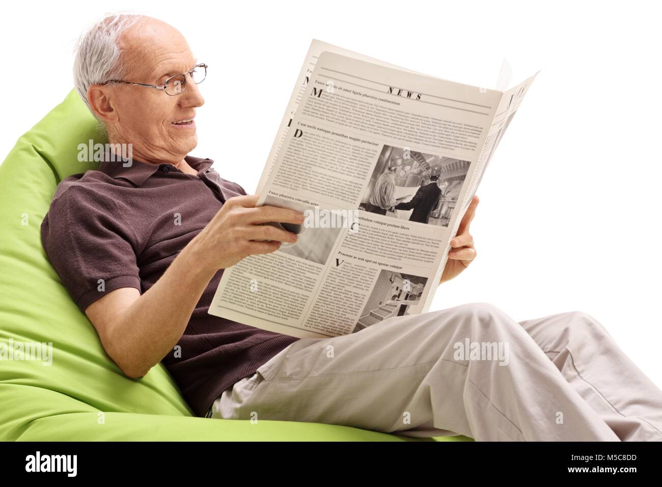 Hauts assis sur un pouf poire et lire un journal isolé sur fond blanc Banque D'Images