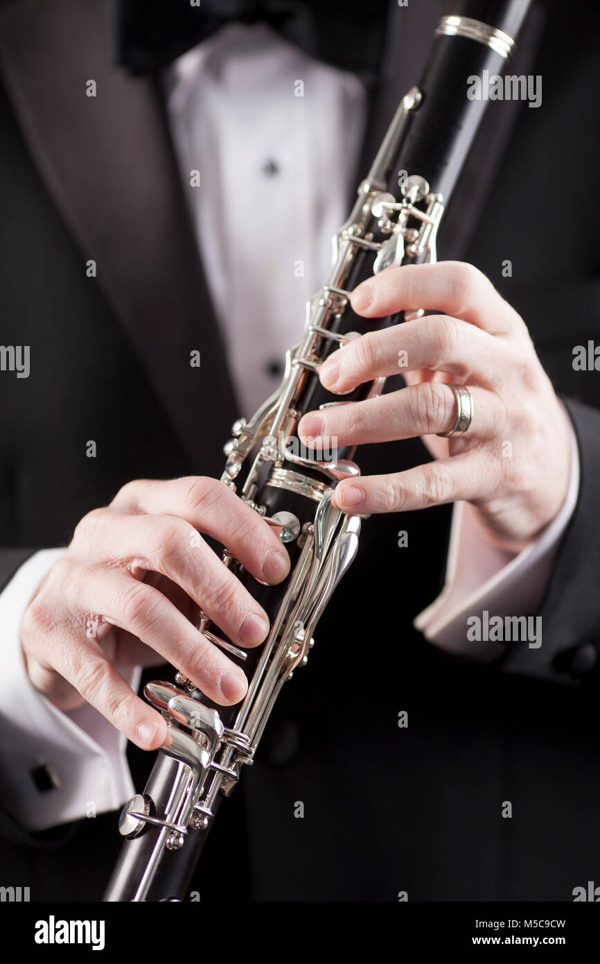 Mains de man in tuxedo holding clarinet, prix pour l'exemplaire Banque D'Images