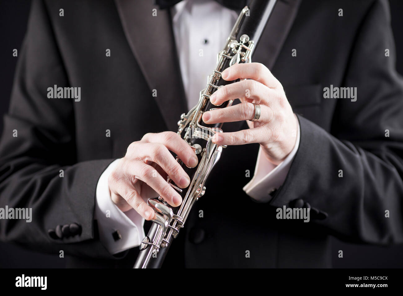 Man in tuxedo holding clarinet, gros plan Banque D'Images