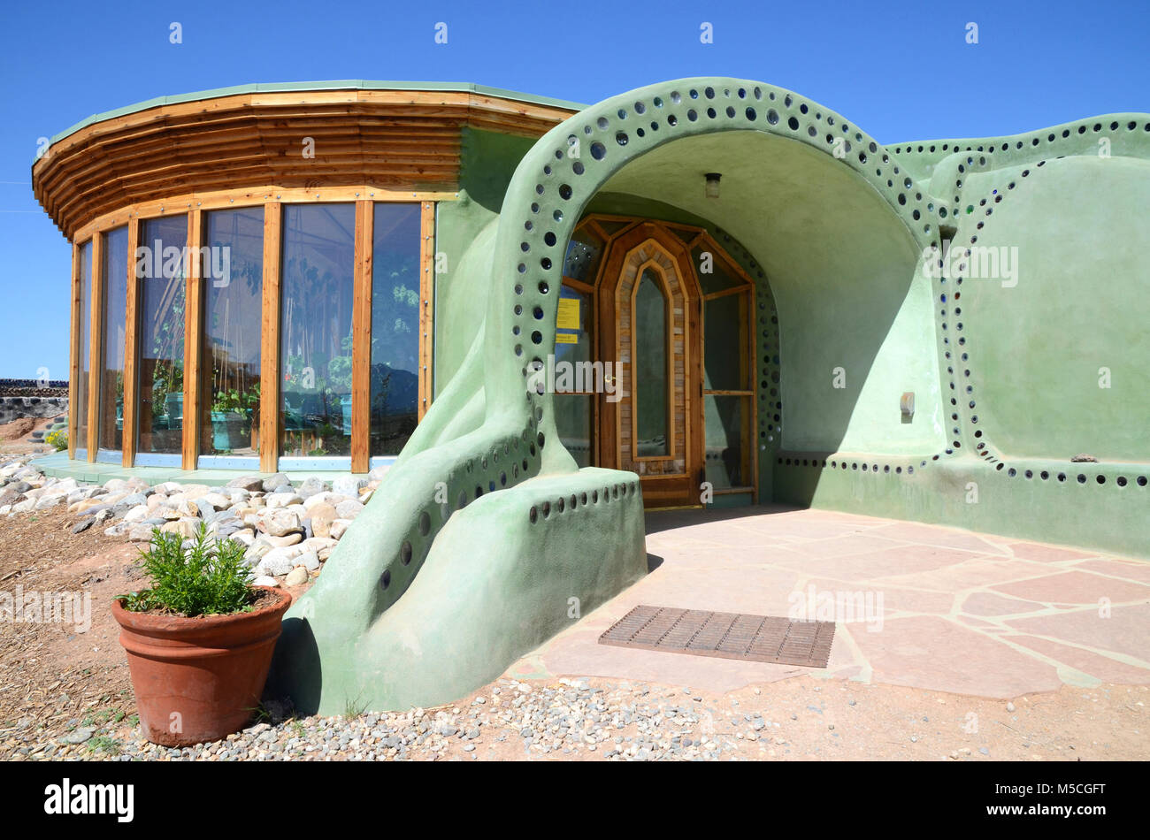 Entrée d'une maison durable Earthship fabriqué à partir d'adobe et des bouteilles en verre upcycled près de Taos dans le Nouveau Mexique, USA Banque D'Images