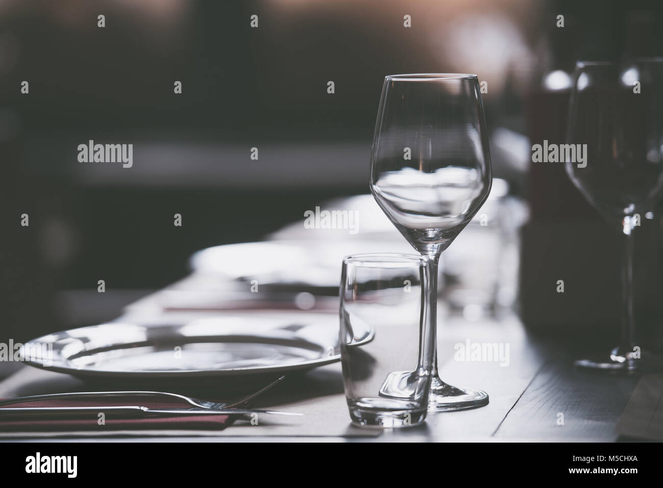 Assiettes et verres vides servi sur une table dans un restaurant prêt pour une célébration Banque D'Images