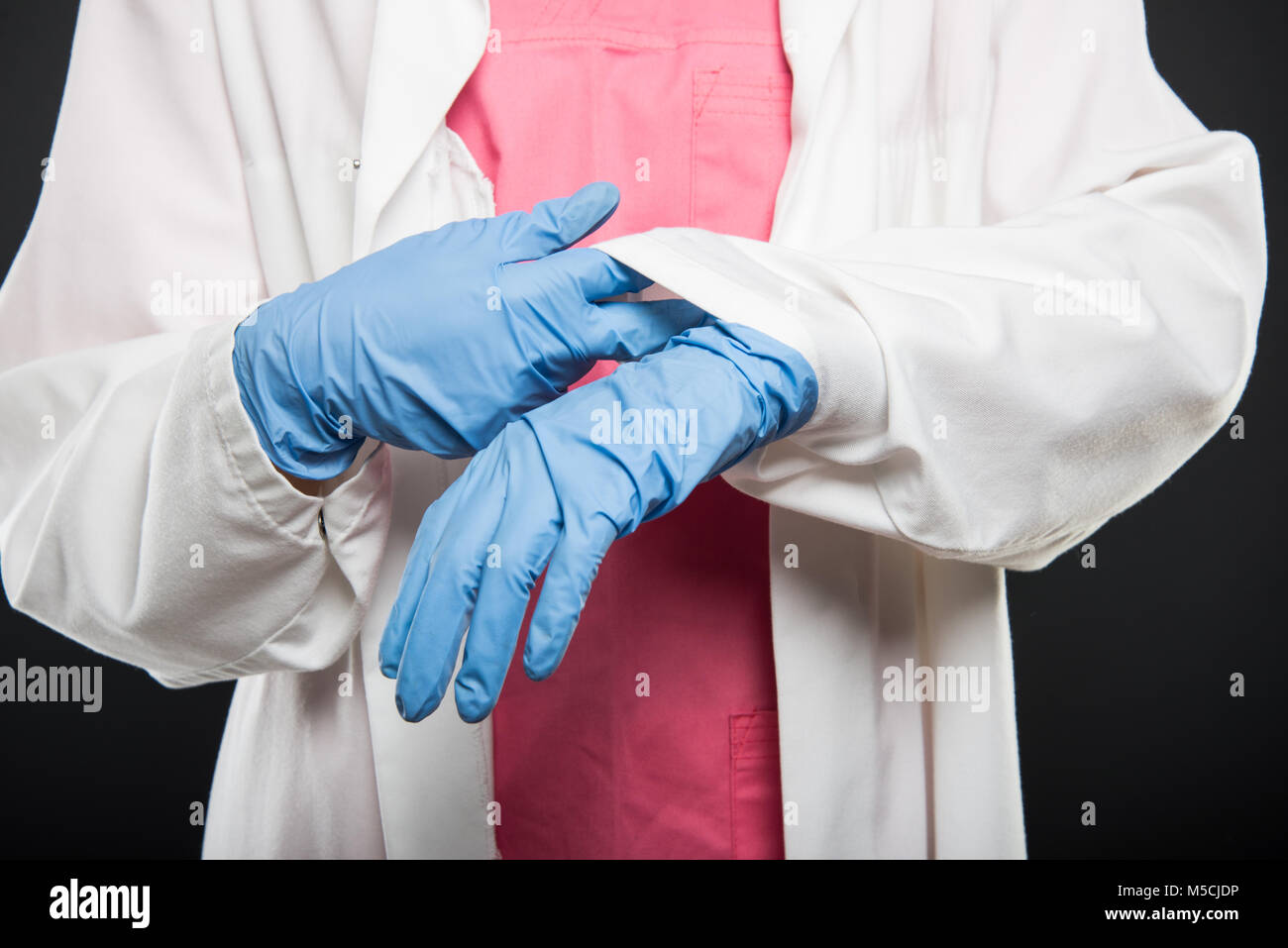 Close-up de médecin d'organiser ses gants stériles sur fond noir Banque D'Images