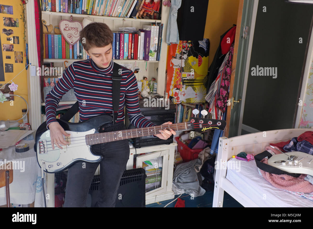 Teenage girl pratiquer son instrument dans sa chambre. Banque D'Images