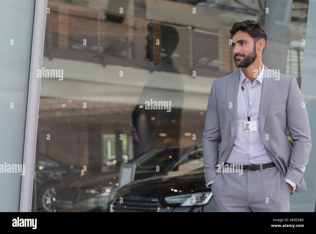 Portrait confiant vendeur de voiture à la voiture à l'extérieur car dealership showroom Banque D'Images