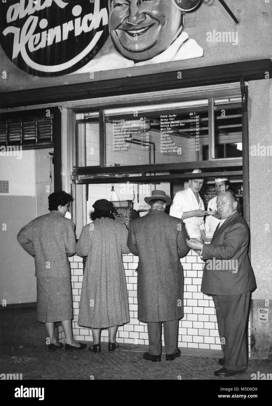 Les hommes et les femmes manger des saucisses, 1960, Berlin, Allemagne Banque D'Images