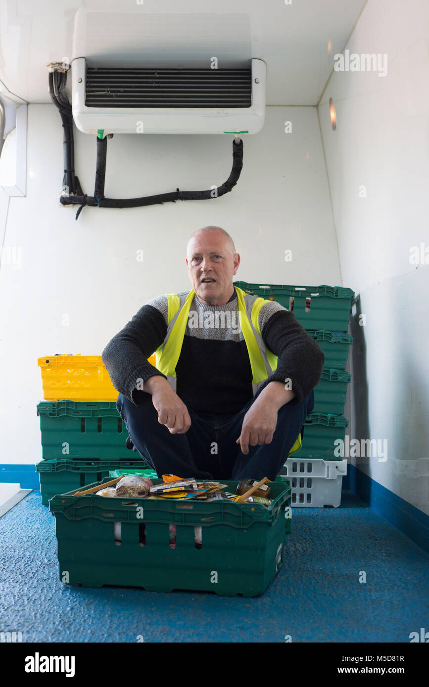 Un homme est assis dans la camionnette d'une entreprise de distribution alimentaire de bienfaisance Banque D'Images