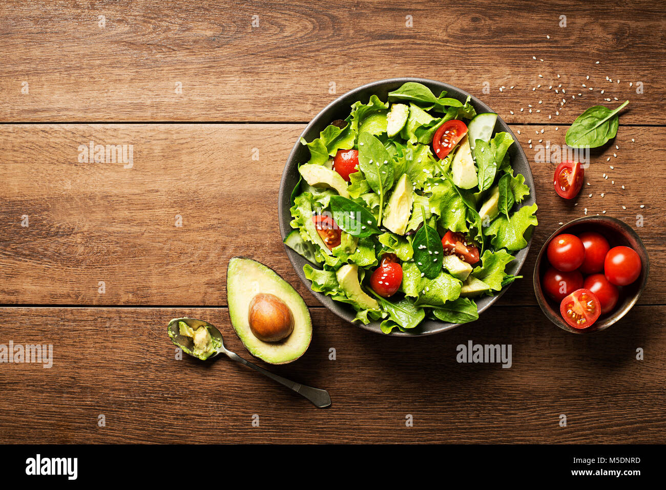 Salade verte à l'avocat et des légumes frais sur fond de bois. Banque D'Images