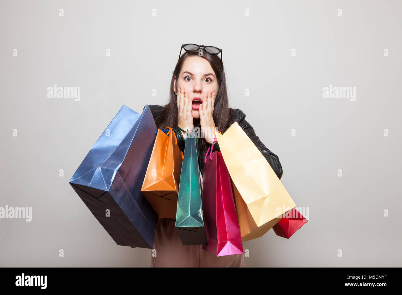 Choqué jolie fille détient shopping bags Banque D'Images