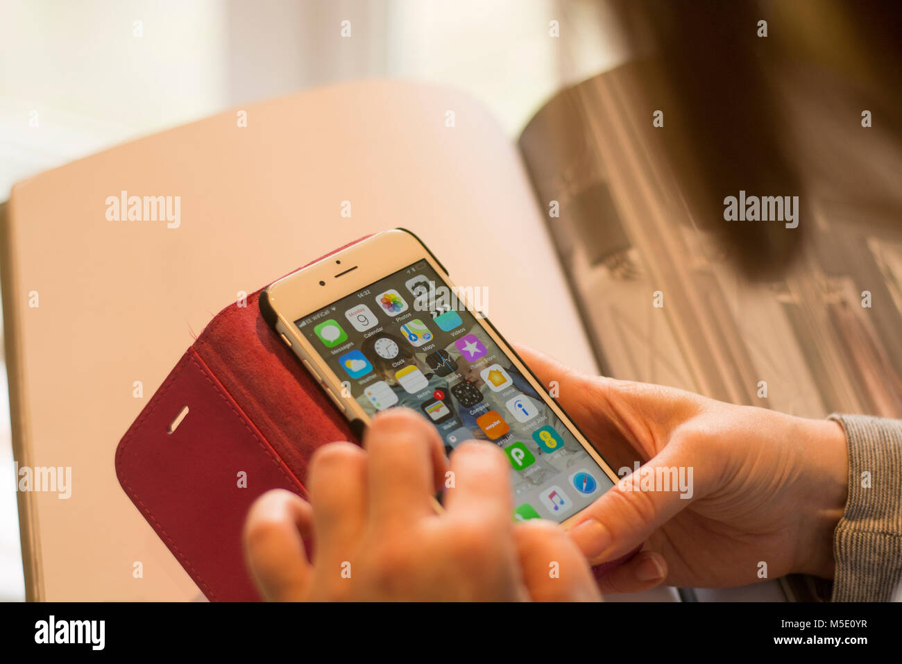 Une femme à l'aide de son iPhone, avec un certain nombre d'applications sur l'écran d'accueil Banque D'Images