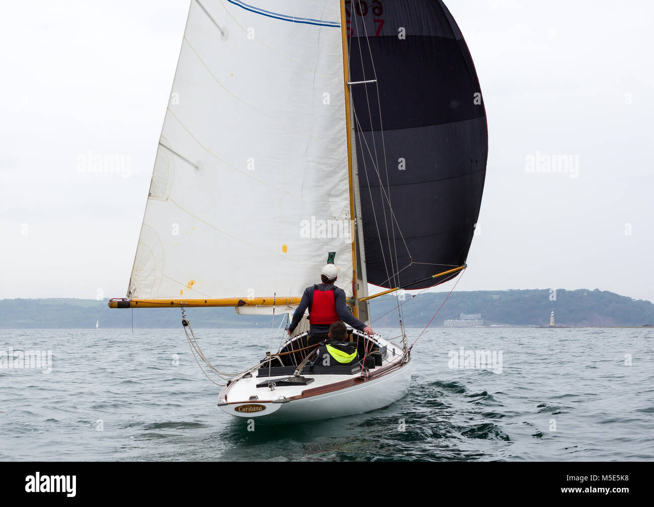 Un membre d'équipage sur le yacht de Caritana le spinnaker mic lors d'une course de bateau classique à Plymouth Sound Banque D'Images