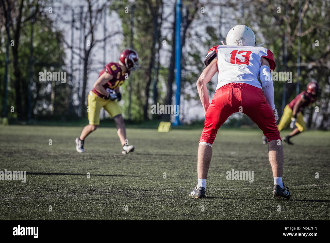 Joueur en maillot rouge et blanc en attendant le prochain jeu d'action Banque D'Images