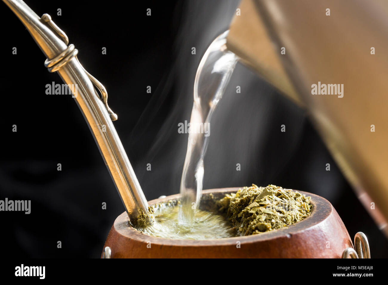 L'Amérique du Sud, Caffeine-Rich traditionnelle boisson infusée Mate (Yerba Mate) dans une calebasse Gourd. L'eau sert à la vapeur électrique en infusion Mate. Banque D'Images